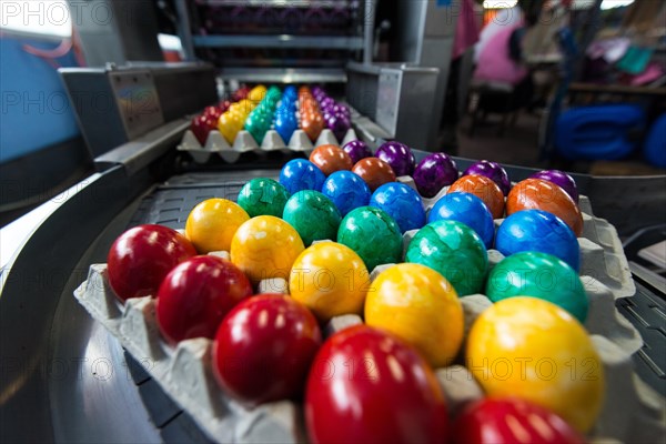 Brightly coloured Easter eggs on a conveyor belt