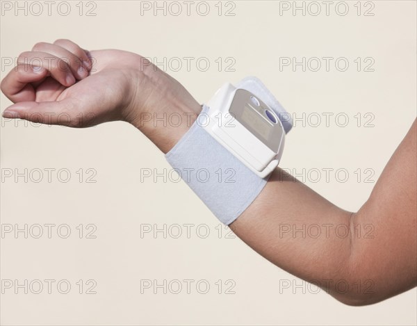 Forearm of a woman with an attached blood pressure monitor