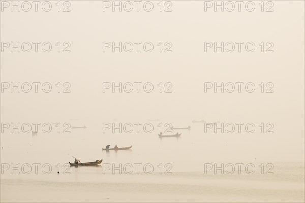 Fishermen in their boats in the morning light
