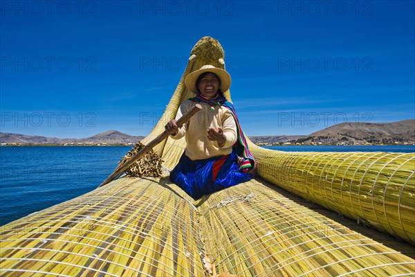 A local woman rowing a traditional boat made of totora reeds on Lake Titicaca