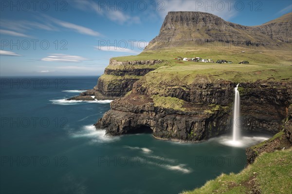 Waterfall on the cliffs near a village