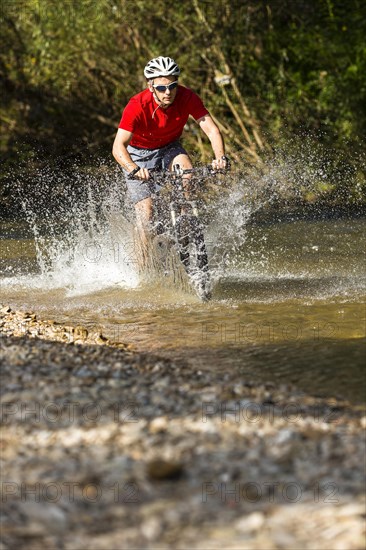 Mountain biker crossing a stream