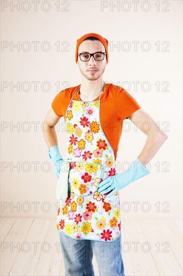 Young man wearing an apron and cleaning gloves
