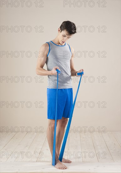 Young man doing fitness exercises with a resistance band