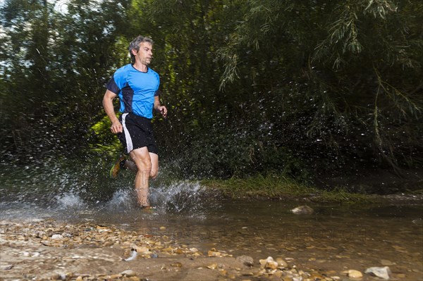 Jogger running through a stream