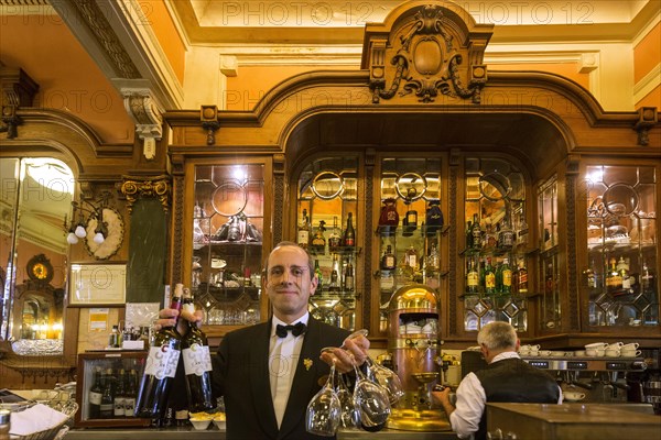 Waiter with wine bottles and glasses