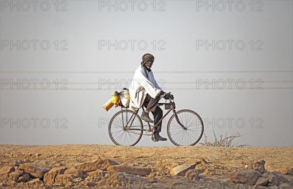 Local resident riding a bicycle at Maga Dam