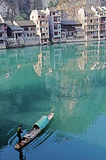 Houses and a fisherman in a boat on the jade-coloured Wuyang River