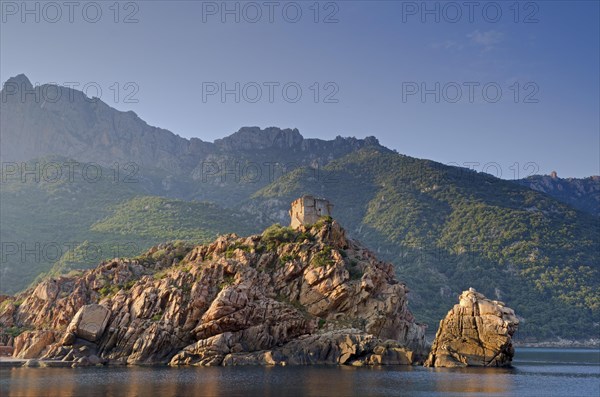 The Genoese Tower of Porto on top of a rocky hill and the Gulf of Porto