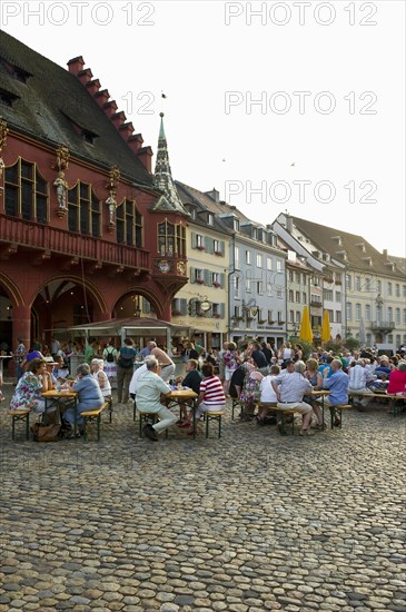 Wine stand and restaurants in front of the Historical Merchants Hall on Muensterplatz square or Cathedral Square