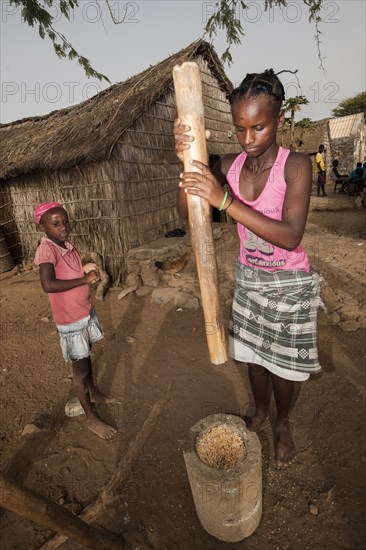 Women of the Rabelados religious community pounding corn in a mortar