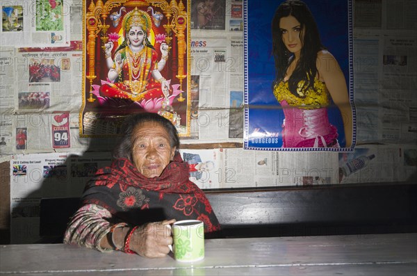 Old woman drinking tea in a local restaurant