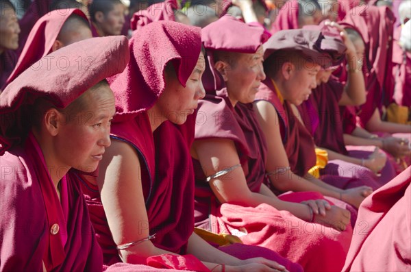 Many nuns wearing red cloths listening the teachings of Taklung Tsetru Rinpoche in the backyard of Junbesi Gompa