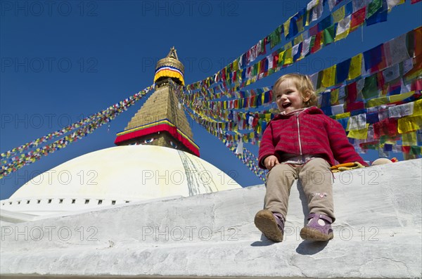 Little tourist child sitting at the foot of Boudnath Stupa