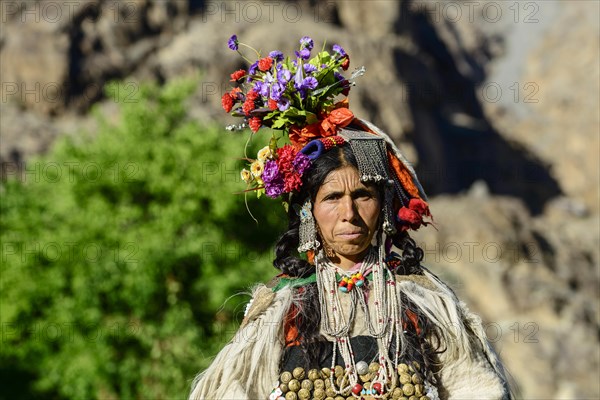 Woman of the Brokpa tribe wearing traditional dress with flower headdress