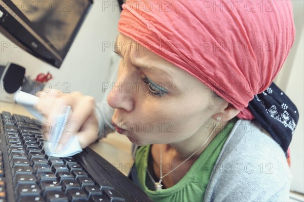 Cleaning lady cleaning a computer keyboard