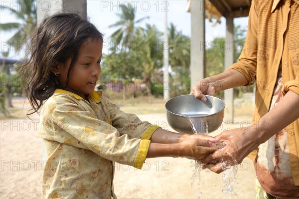 Woman washing a girl's hands