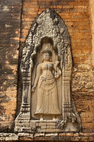 Bas-relief of a female deity wearing a long robe and holding a fly-whisk in her hand