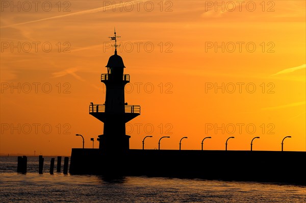 Silhouette of the Brunsbuttel Mole 1 lighthouse in front of a evening sky