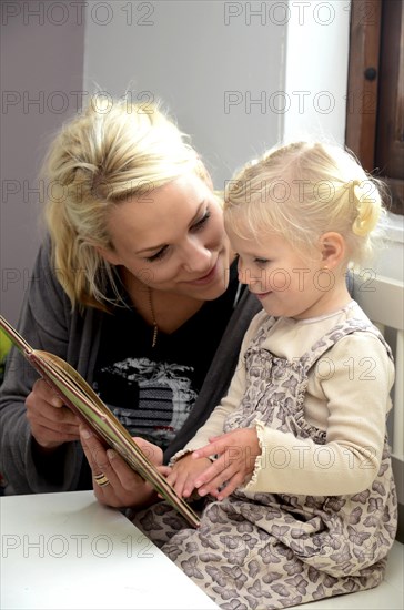 Mother reading a book with her little daughter