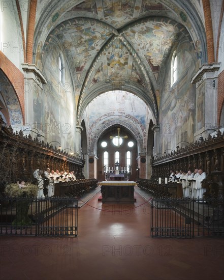 Cistercian monks in prayer in the Gothic Chiaravalle Abbey