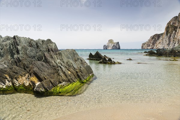 Spiaggia di Masua bay with the Pan di Zuccherof rock island in the sea