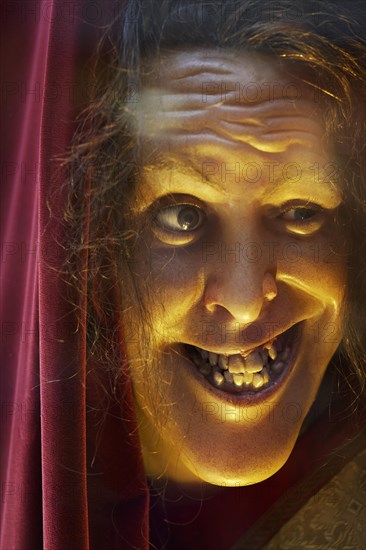 Face of a grinning wax figure with broken teeth