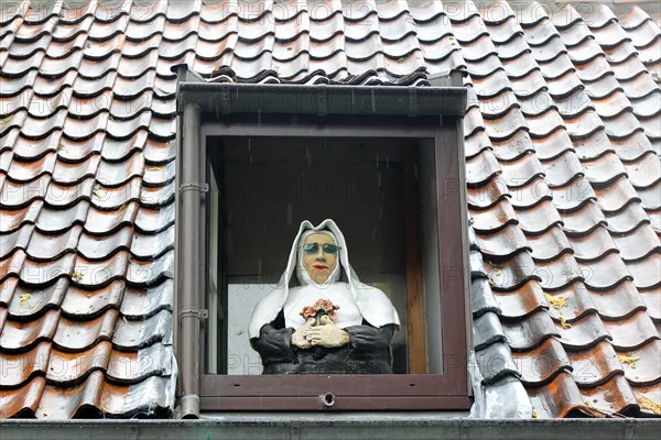 Caricature of a nun in a window