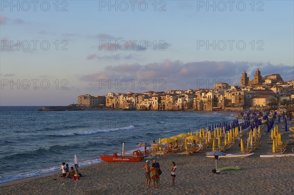 Beach and historic town centre with Cathedral of San Salvatore at dusk