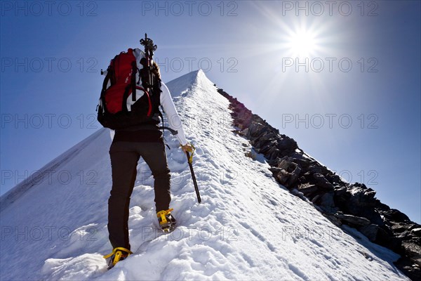 Mountain climber ascending Hochfeiler Mountain along the summit ridge