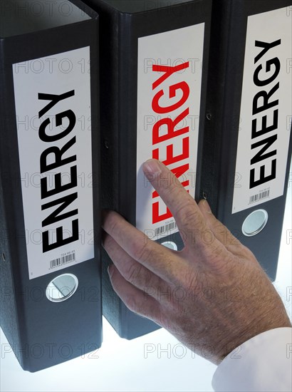 Hand reaching for a ring binder labeled Energy