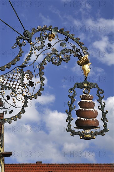 Hanging sign with a 'Baumkuchen' or tree cake from the Kaffeehaus Trexler coffee house