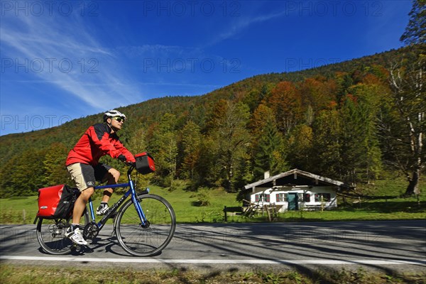 Tourist on a bicycle cycling on front of a hut