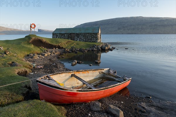 Red boat in front of a boat house on Lake Sorvagsvatn or Leitisvatn