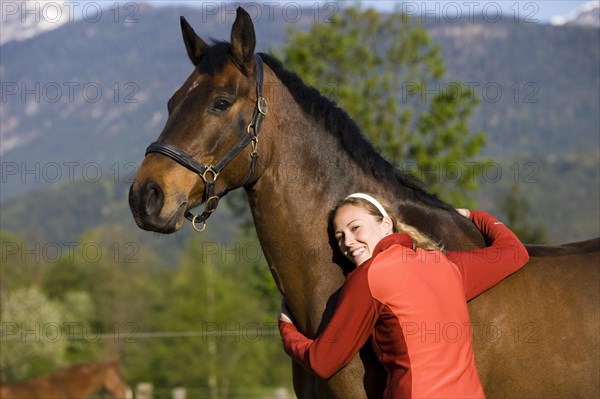 Young woman embracing an Austrian Warmblood