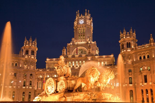 Illuminated Fuente de Cibeles fountain in front of the Palacio de Comunicaciones