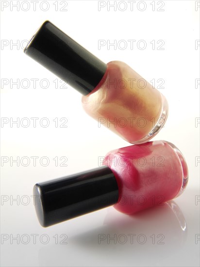 Two nail varnish bottles balanced on each other