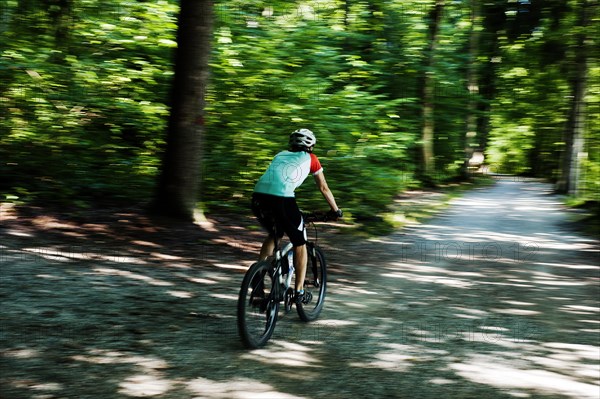 Woman riding a mountain bike along the Forstweg trail in Feldafinger Park