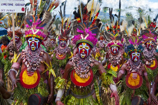 Members of a tribe in colourfully decorated costumes with face paint at the traditional sing-sing gathering