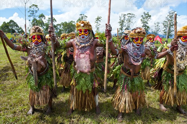 Members of a tribe in colourfully decorated costumes with face paint at the traditional sing-sing gathering