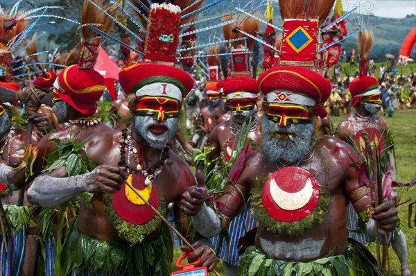 Members of a tribe in colourfully decorated costumes with face paint at the traditional sing-sing gathering