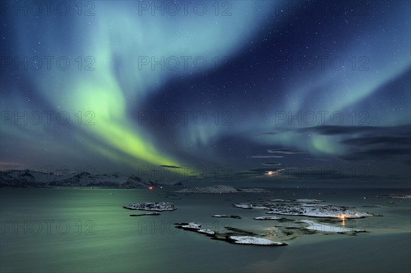 Fjord with islands in winter and the northern lights