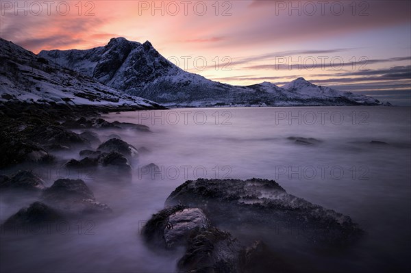 Fjord with mountain range in the evening light in winter