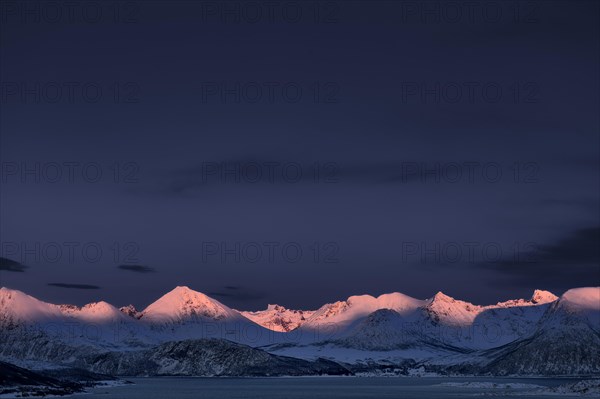 Fjord with mountain peaks during the blue hour