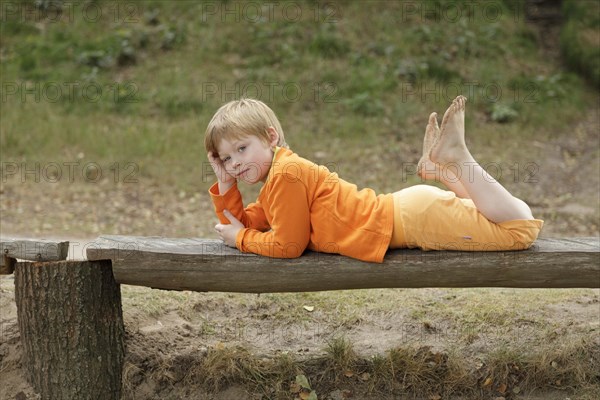 Little boy lying on a bench