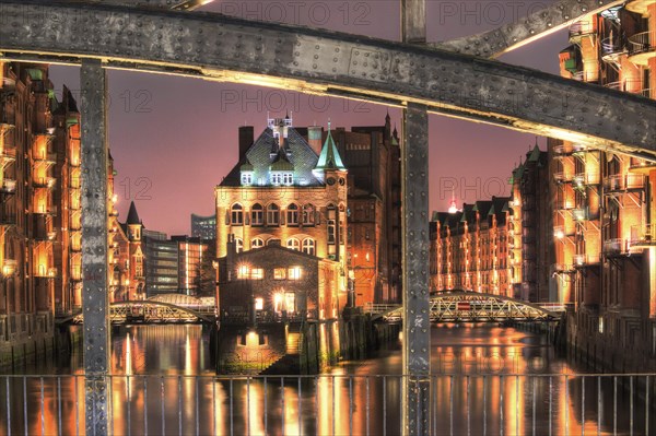 View through Poggenmuehlenbruecke bridge towards Wasserschloesschen water castle at night