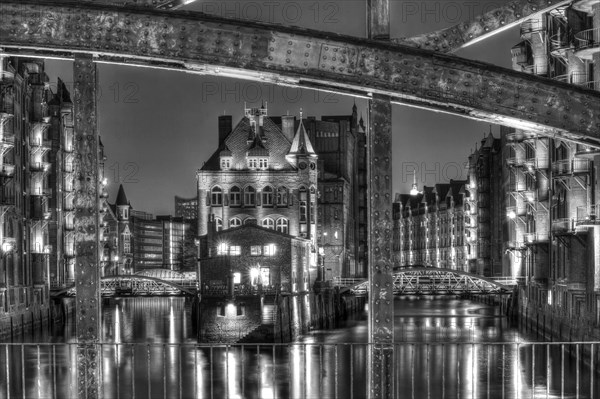 View through Poggenmuehlenbruecke bridge towards Wasserschloesschen water castle at night