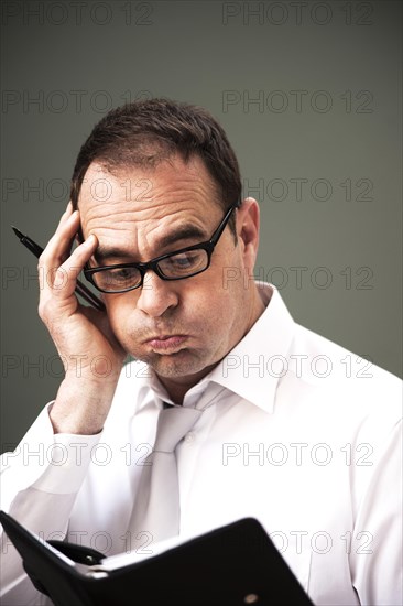 Businessman wearing glasses looking at his appointment calendar