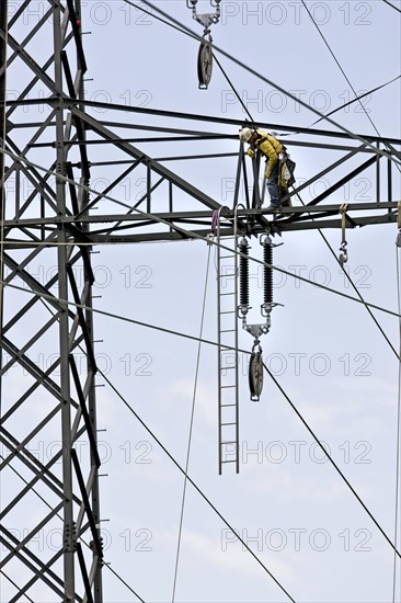 High voltage technician installing a new high-voltage power line
