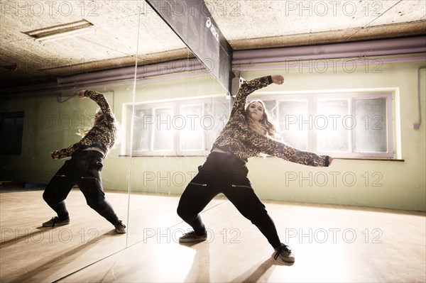 Breakdancer dancing in front of a mirror wall